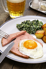 Leberkäse with spinach, potatoes and fried egg, Austria and southern German dish