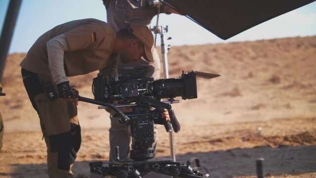Filming in the steppe. The operator moves the video camera along the slider. Film crew. Movie production in the desert