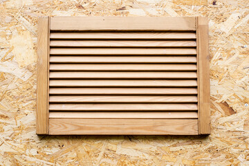 wooden blinds on the window of the summer shower cabin made of OSB