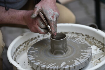 Detail shot with hands of a potter making handmade pottery