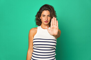 Young caucasian woman isolated standing with outstretched hand showing stop sign, preventing you.