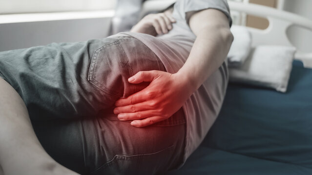 Close up man suffering from hemorrhoids.