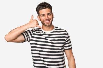 Young handsome man isolated showing a mobile phone call gesture with fingers.