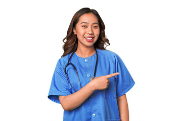 A young nurse chinese woman smiling and pointing aside, showing something at blank space.