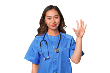 A young nurse chinese woman smiling cheerful showing number five with fingers.