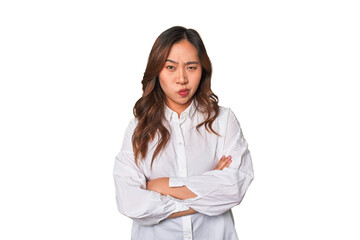 A young chinese woman frowning face in displeasure, keeps arms folded.