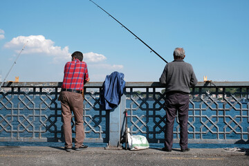 Fishermen on the Galata Bridge, famous fishing road in the center of Istanbul, Turkey 