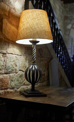 lamp with fabric shade and wrought iron base on wooden table
