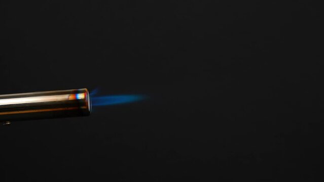 blue orange flame of the gas lights up, burns and gradually goes out. closeup of flame from gas burner pipe burning from the nozzle on black background. concept of gas shortage and rising prices.
