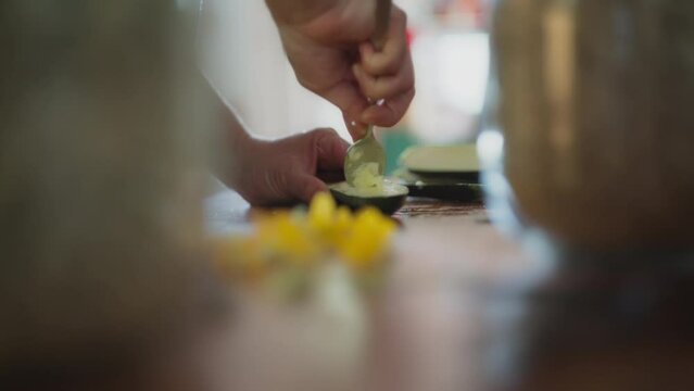 Removing inside of zucchini with a spoon to make stuffed vegetables. Slow motion, shallow depth of field.  Generative AI