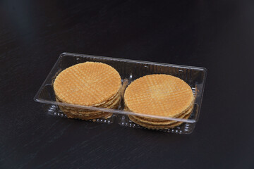 Delicious cookies in plastic packaging on a dark background