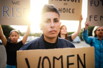 Crowd of feminist women protest for female rights holding signs at demonstration outdoor -...