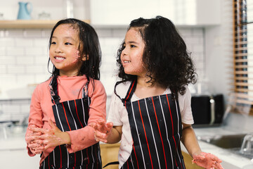 happy funny kids are preparing the , bake cookies in the kitchen, girl are cooking cookies and having fun in the kitchen.
