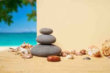 Invitation or greeting card mockup with seashells and pyramid of stones on the summer sandy beach