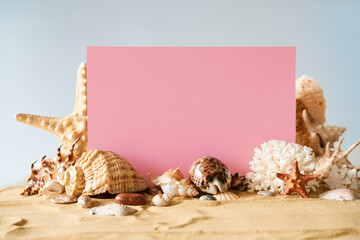 Invitation or greeting card mockup with seashells and starfish on the summer sandy beach at ocean...