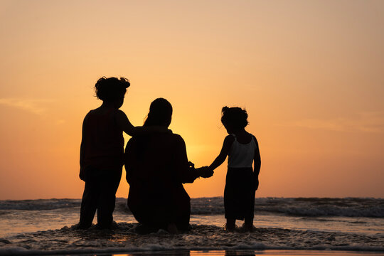 Mother's day concept image, Mother and children's playing on the beach at sunset, 