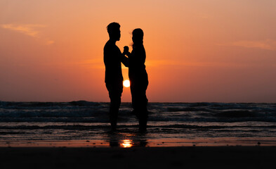 Couple Appreciation Day concept image, lovers enjoying the sunset view from the beach