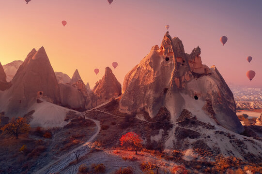 Old ancient home cave in big stone, hot air balloons fly over deep canyons, valleys Cappadocia Goreme National Park, Turkey Travel tourist concept