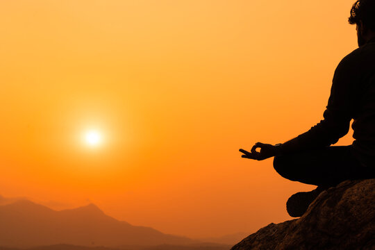 Yoga day concept image, Young person doing yoga on mountain during sunset, relaxing and World meditation day concept image