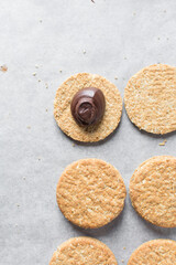 top view of oat cookies with chocolate filling, homemade oatmeal cookies filled with chocolate ganache, thin oat biscuits with chocolate ganache