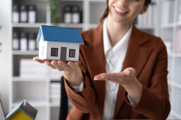 Close up view og real estate agent with house model. home loan and insurance concept.