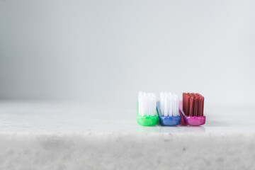 Blue, pink and green toothbrush with white bristles on a white background, colorful toothbrushes with copyspace