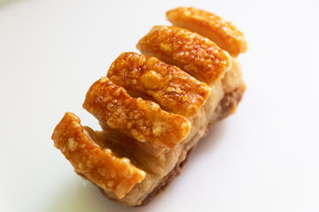 Crispy roast pork belly on white cutting board.