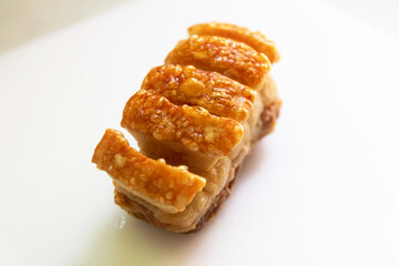 Crispy roast pork belly on white cutting board.
