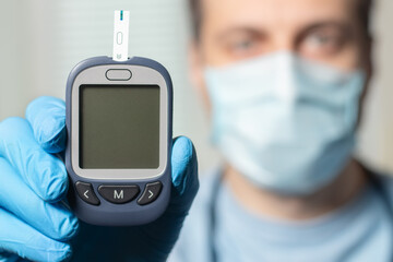 Doctor shows glucometer with glucose level. Doctor and patient diabetes consultation in office or clinic.