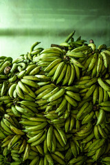 Heap of green bananas at market
