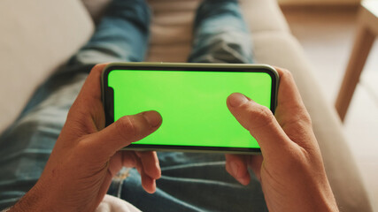 Guy dressed in denim shirt has lunch, sits in the living room and emotionally watches sports game on TV