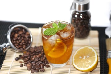 Americano Ice Coffee,with lemon water,coffee beans,tamper,lemon,bamboo bar matrefreshing and good feeling,topping by lemon slice,concept isolate and copy space.