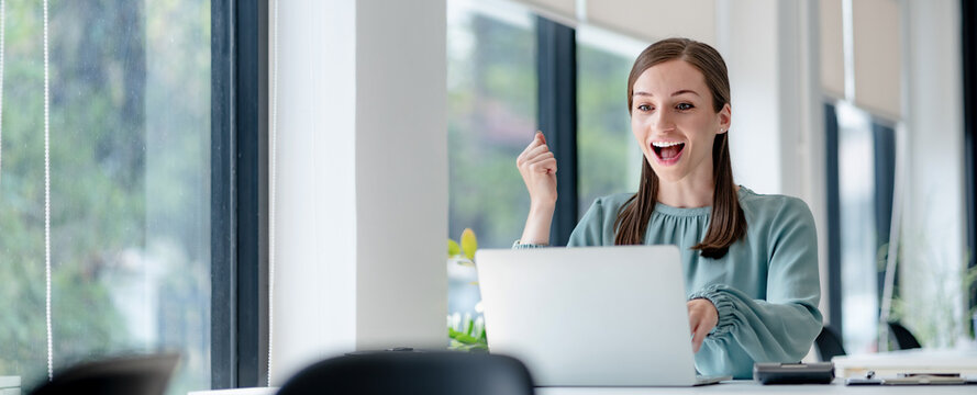 Excited business woman surprise looking on laptop having a good news..