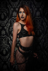 Fototapeta na wymiar gothic girl gothic model alternative girl lingerie boudoir model in front of gothic pattern background with focus on face