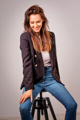 Attractive mid aged woman cheerful smiling and sitting at isolated background