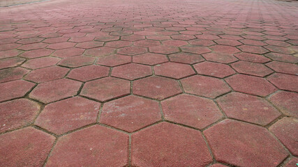 Footpath concrete block. hexagon red paving blocks. The texture of the paved tile on the bottom of the street. Cement brick squared stone floor background. Concrete paving slabs. Paving slabs.