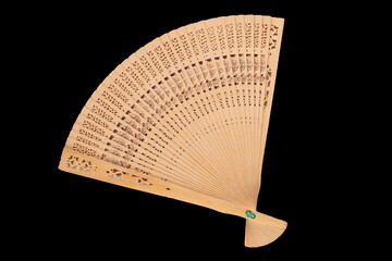 One wooden fan, macro, isolated on black background, top view.