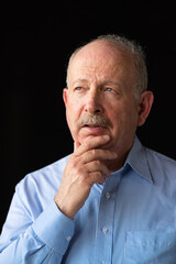 Grey haired senior man with mustache wearing eyeglasses and thinking