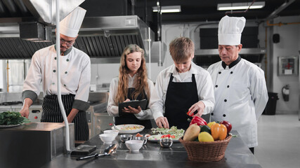Chef and students cooking and preparing food in kitchen. Cooking class for children. food and...