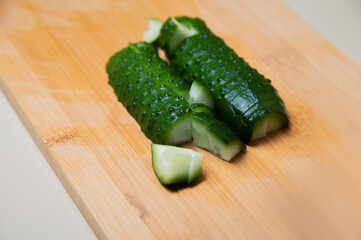 slices of fresh cucumber, on a wood background. top side view, cooking on a cutting board, close-up