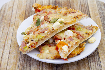 Leftover cold pizza slices on a plate