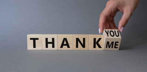 Thank You or Me symbol. Businessman Hand turns cubes and changes words Thank Me to thank you. Beautiful grey background. Business and Thanks concept. Copy space
