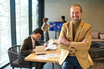 Cheerful mature director of business company or corporation looking at camera with smile while...