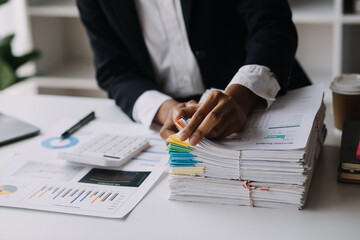 Financial analysts analyze business financial reports on a digital tablet planning investment project during a discussion at a meeting of corporate showing the results of their successful teamwork.