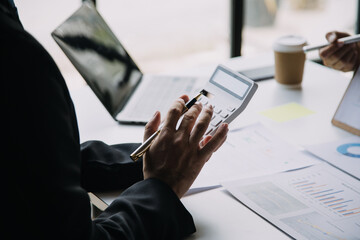 Financial analysts analyze business financial reports on a digital tablet planning investment project during a discussion at a meeting of corporate showing the results of their successful teamwork.