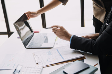 Financial analysts analyze business financial reports on a digital tablet planning investment project during a discussion at a meeting of corporate showing the results of their successful teamwork.