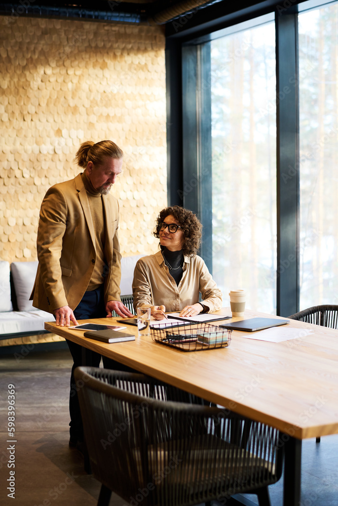 Aufkleber two mature economists discussing financial documents or brainstorming and organizing work while one 