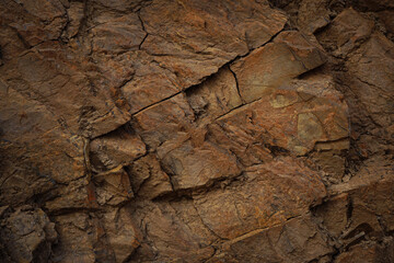 Dark red brown rock texture. Mountain surface. Close-up. Stone granite basalt background. 3d shape. Nature. Natural. Volumetric. Rough, cracked, crushed, broken, ruined. Backdrop