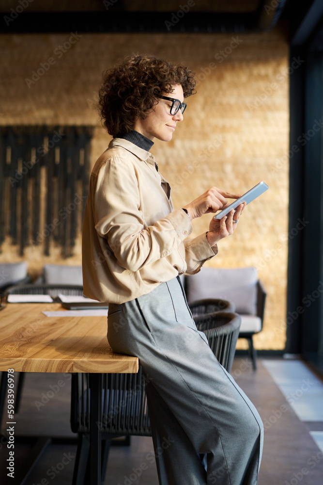 Aufkleber side view of young confident female analyst in quiet luxury attire pointing at tablet screen while s