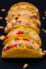 Five taco shells on black background